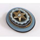 A late Victorian banded agate stick pin set with a pearl on a gold metal star. Approx.