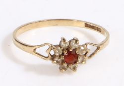 A 9ct gold ring set with a garnet and cubic zirconia and decorative heart shoulders. Ring size R.