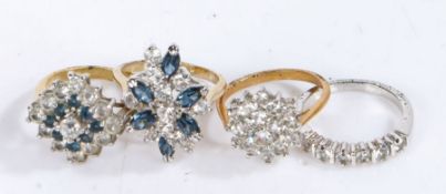 Four costume rings with blue and white stones. Gross weight: 12.80 grams.