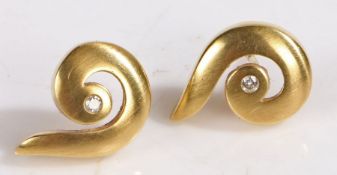 A pair of 18ct gold and diamond earrings in the form of swirl, with a diamond in each. Total approx.