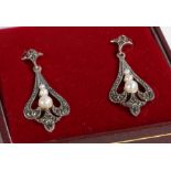 A pair of art deco style drop earrings set with pearls. Encased in a jewellery box.