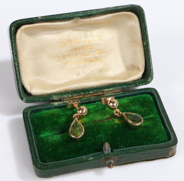 A pair of 9ct gold drop earrings set with pear cut Peridot. Weighing 2.6 grams. Encased in a green