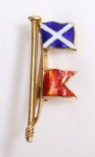 A 9ct yellow gold flag pole brooch with two enamel flags. Measurements: 30 x 11mm. Weighing 2.40