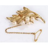 A 14ct yellow gold leaf shaped brooch with five round pearls and a safety chain. Diameter 50mm.