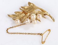 A 14ct yellow gold leaf shaped brooch with five round pearls and a safety chain. Diameter 50mm.