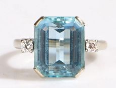 A 14ct white metal ring set with one emerald cut aquamarine, with one diamond each side. Approx.