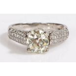 A platinum diamond ring with diamond set shoulders. Central diamond approx. carat weight: 1.30cts.