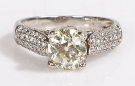 A platinum diamond ring with diamond set shoulders. Central diamond approx. carat weight: 1.30cts.