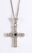An 18ct white gold crucifix pendant set with one sapphire and diamonds suspended from an 18ct