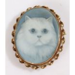 A yellow metal, onyx backed carved agate cameo brooch - image of a cat. Length: 32mm. Weighing 11.