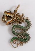 A yellow metal Chinese pendant with green and red enamel dragon holding a ball in its jaws. Length