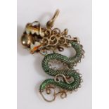 A yellow metal Chinese pendant with green and red enamel dragon holding a ball in its jaws. Length