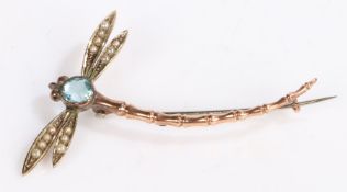 A 9ct yellow gold dragonfly brooch. With aquamarines set to the body and pearl set eyes. Length