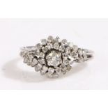 An 18ct white gold diamond halo ring. One central round cut diamond, approx. carat weight 0.
