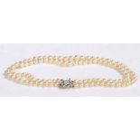 A double stranded,creamy yellow pearl necklace, individually knotted in a graduating design, with an
