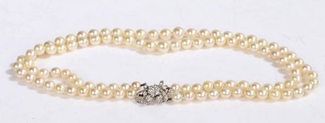 A double stranded,creamy yellow pearl necklace, individually knotted in a graduating design, with an
