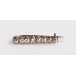 A Victorian diamond set bar brooch, with eight round diamonds on yellow and white metal. Total