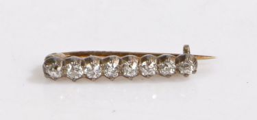 A Victorian diamond set bar brooch, with eight round diamonds on yellow and white metal. Total