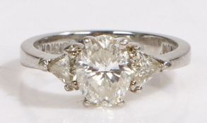 A platinum diamond trilogy ring. One central oval cut diamond with an E.G.L diamond certificate.