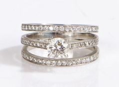 A platinum three band diamond ring. Central diamond approx. carat weight: 0.70cts. Colour: H.