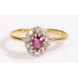 An 18ct yellow and white gold ruby and diamond cluster ring. Approx. carat weight of ruby: 0.