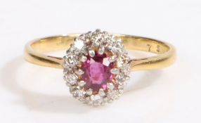 An 18ct yellow and white gold ruby and diamond cluster ring. Approx. carat weight of ruby: 0.