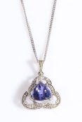 An 18ct white gold pendant set with tanzanite and three diamonds suspended from an 18ct white gold