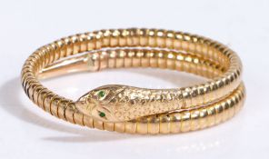 A 9ct yellow gold articulated snake bangle, the head set with green emeralds for eyes.  Approx.