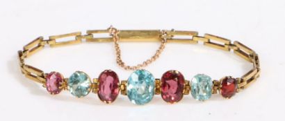 A 14ct yellow gold bracelet set with garnet and aquamarines. Approx. length 19cm. Weighing 6.70