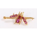 A yellow metal ruby and pearl set insect brooch. With rubies set for the body and wings, and pearl