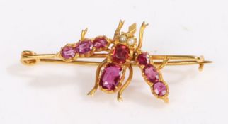 A yellow metal ruby and pearl set insect brooch. With rubies set for the body and wings, and pearl