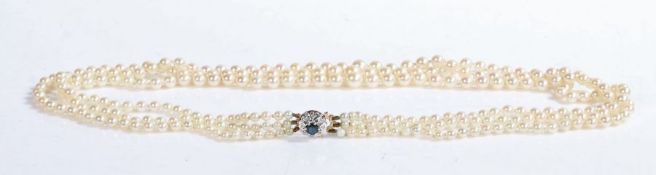 A three-row graduated Akoya pearl necklace with a 9ct white gold sapphire and diamond cluster clasp.