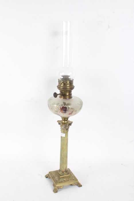 19th century oil lamp with a clear glass chimney going down to a frosted and coloured glass