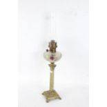 19th century oil lamp with a clear glass chimney going down to a frosted and coloured glass