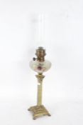 19th century oil lamp with a clear glass chimney going down to a frosted and coloured glass