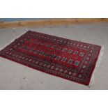 Pakistani wool rug, the red ground with multiple elephants foot and diamond lozenges and multiple