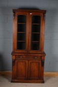 Victorian mahogany bookcase, with carved foliate decoration above two glazed doors and a cupboard