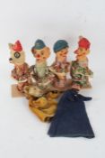 Set of four painted puppets, each with terracotta coloured faces and hands, with wooden stand,