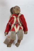 Early to mid 20th century straw filled monkey, in red military uniform, bearing label "I do  not