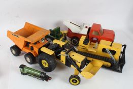 Three Tonka toys, to include a wrecker truck, dozer and a tractor, together with a Mogul tipper