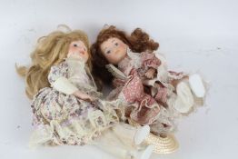 Two porcelain headed doll, "The Classique Collection", each with floral dresses and hats (2)
