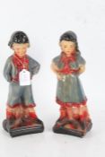 Pair of Art Deco plaster figures, in the form of a young boy and girl in blue and red costumes, (the