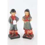 Pair of Art Deco plaster figures, in the form of a young boy and girl in blue and red costumes, (the