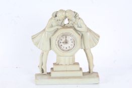 Art Deco plaster mantel clock, with two ladies either side of a circular dial, 20cm wide