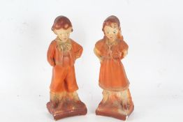 Pair of Art Deco plaster figures, each in the form of a young girl and boy in orange outfits, 31cm