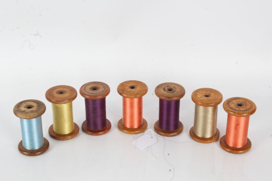 Seven wooden thread spools, one stamped "Courtaulds Ltd. Leigh", and another "Wilson Bros.