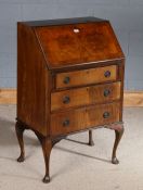 20th century mahogany veneered bureau, with a sloping fall above three draws raised on cabriole