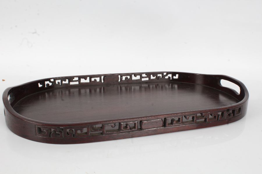 Chinese hardwood tray, of oval form with pierced carved gallery, 49.5cm wide, 29cm deep