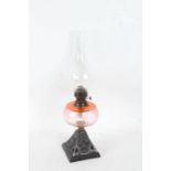 20th century oil lamp with a clear glass bulbous chimney and a cranberry glass reservoir, 54cm high