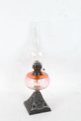 20th century oil lamp with a clear glass bulbous chimney and a cranberry glass reservoir, 54cm high